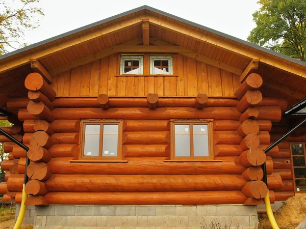 Front side of new built beams in cabin house. Painted wood with fungicide light red paint. — Stock Photo, Image