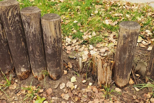 Gebroken hek, oude houten stockade, palisade, steenachtige achtergrond — Stockfoto