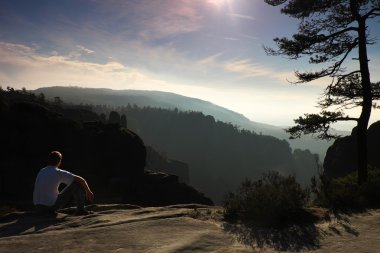 Adam'in rock empires park ve sonbahar puslu Vadisi izlerken oturmak. Güneşli sonbahar günü.