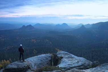 Kumtaşı kaya ve puslu ve sisli sabah Vadisi izlerken tepe üzerinde turist konaklama.