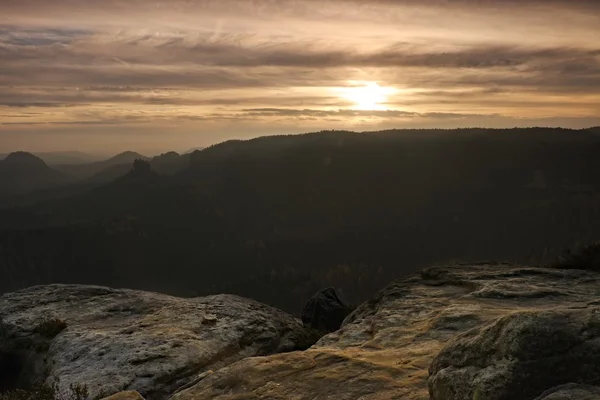 Salida del sol en una hermosa montaña de la Suiza checo-sajona. Picos de arenisca aumentados a partir de fondo brumoso, la niebla es de color naranja debido a los rayos del sol . —  Fotos de Stock