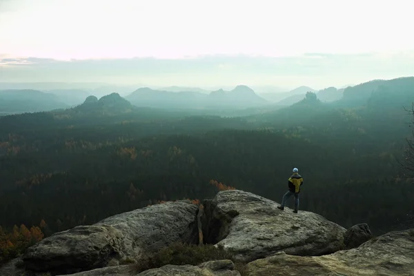 Tourist stay on the peak of sandstone rock and watching over the misty and foggy morning valley. — Stock Photo, Image