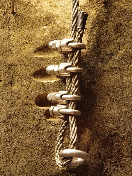 Escaladores. Ferro corda torcida fixada em bloco por parafusos encaixe ganchos. A extremidade da corda ancorada em pedra de arenito . — Fotografia de Stock