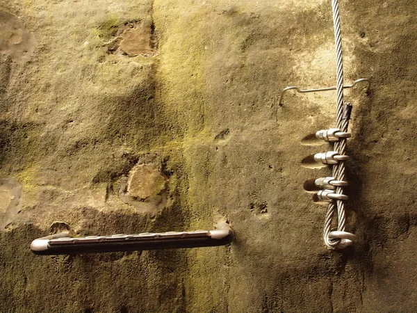 Climbers way. Iron twisted rope fixed in block by screws snap hooks. The rope end anchored into sandstone rock. — Stock Photo, Image