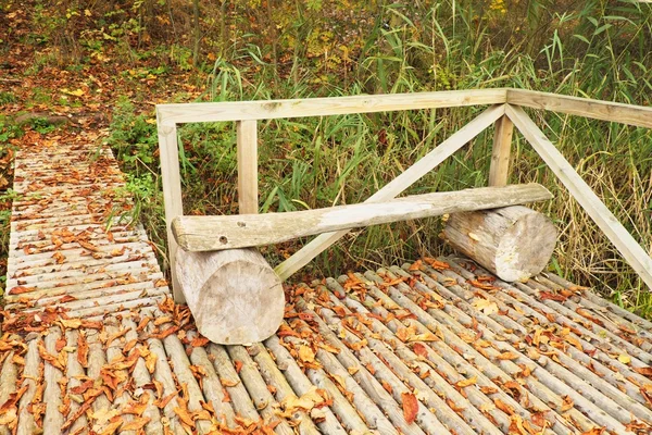Ξύλινο μονοπάτι με πολύχρωμο φθινόπωρο ξηρά φύλλα, ξύλο γέφυρα για πεζούς, ξύλινη κατασκευή — Φωτογραφία Αρχείου