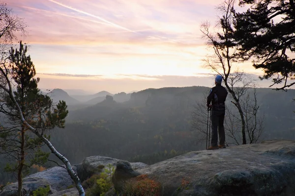 Sportsman está de pie sobre la roca en el parque de imperios rocosos y vigilando el brumoso y brumoso valle matutino hasta Sun. Hermoso momento el milagro de la naturaleza — Foto de Stock