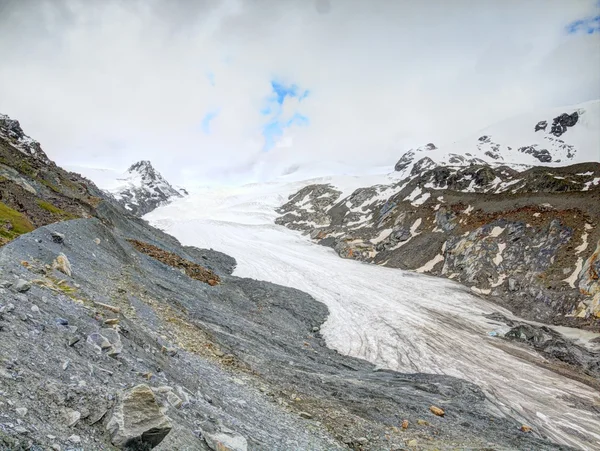 Isberg Findelgletscher i stenig dal bälg Adlerhorn massivet, Zermatt regionen, Schweiz. Resten av is i slutet av hösten, första snö på klipptoppar ovan — Stockfoto