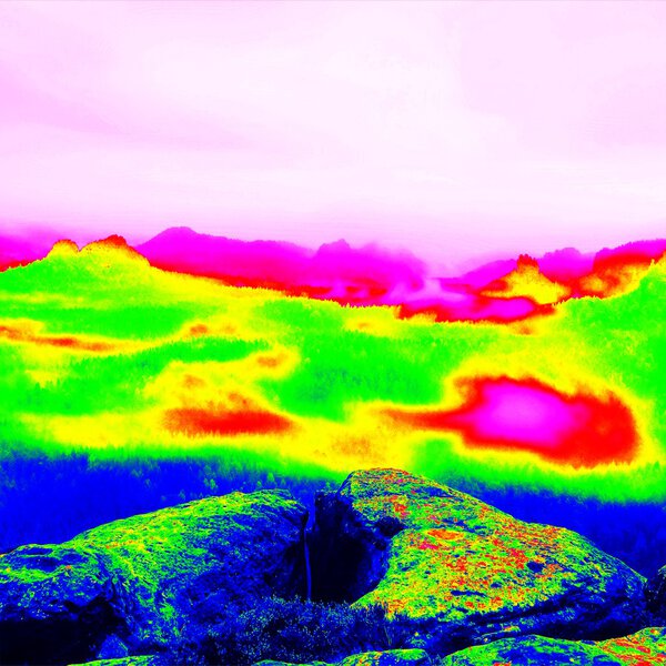 Fantastic infrared scan of rocky  landscape, pine forest with colorful fog, hot sunny sky above. Grunge background in thermography colors.