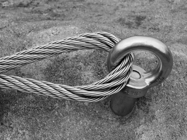 Detail of rope end of ferrata way anchored into sandstone rock. Iron twisted rope fixed in block by screws snap hooks. — Stock Photo, Image