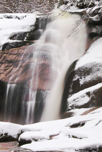 Vista invernale su massi innevati a cascata di cascata. Livello dell'acqua ondulata.. Flusso in surgelazione . — Foto Stock