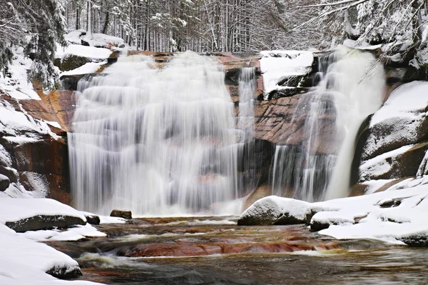 Vista de inverno sobre pedras nevadas para cascata de cachoeira. Nível de água ondulado.. Fluxo em congelamento profundo . — Fotografia de Stock