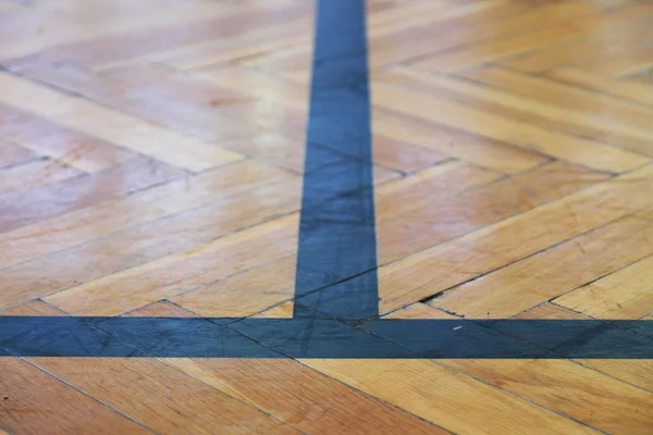 Зношена дерев'яна підлога спортивного залу з барвистими лініями розмітки . — стокове фото