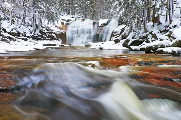 Winter uitzicht over besneeuwde rotsblokken aan cascade van waterval. Golvend waterpeil.. Stroom in diepvries. — Stockfoto