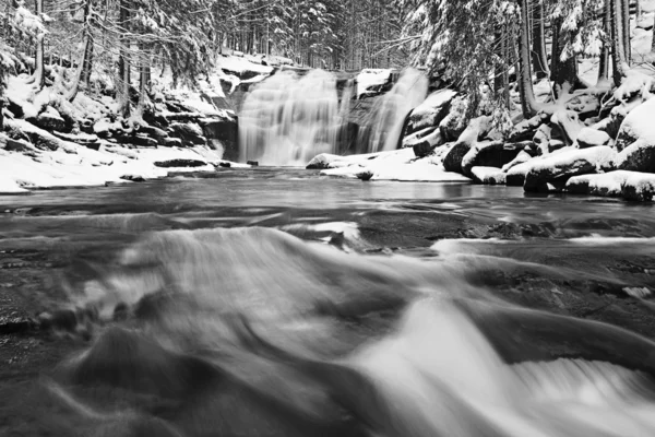Téli kilátás havas sziklák vízesés zuhogása. Hullámos vízszint... Fagyott patak. — Stock Fotó
