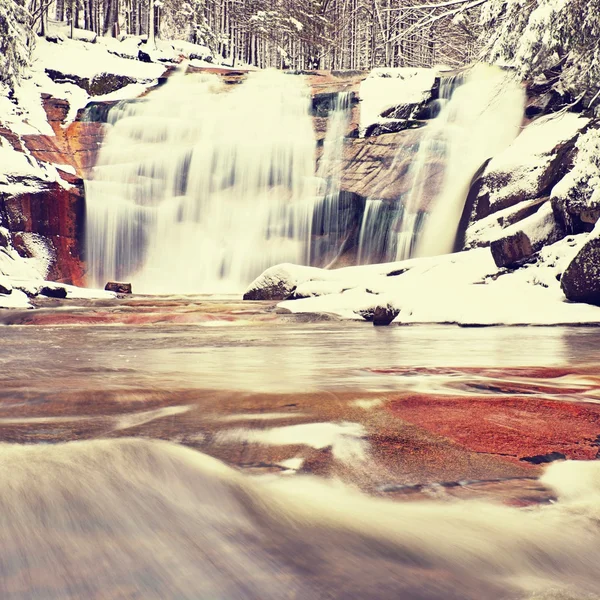 Zimní pohled na zasněžené balvany ke kaskádě vodopádu. Vlnitá hladina vody. Proud v hlubokém mrazu. — Stock fotografie