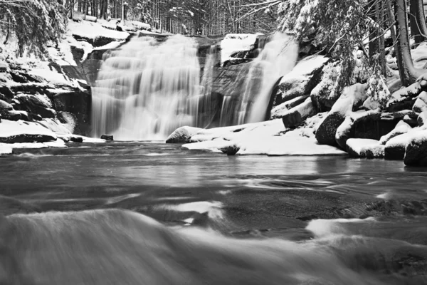 Vista invernale su massi innevati a cascata di cascata. Livello dell'acqua ondulata.. Flusso in surgelazione . — Foto Stock