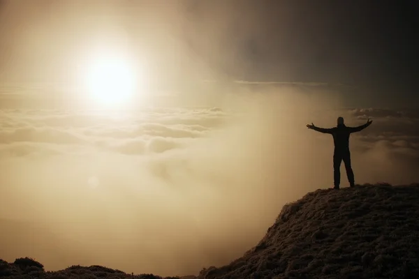 Τουριστικά με τα μαύρα στην κορυφή. Χειρονομία του Θριάμβου. Κουρασμένος τουριστικά στην κορφή του κατεψυγμένα χόρτο κορυφή λόφου στο Άλπεις εθνικό πάρκο βλέποντας σε ομίχλη. — Φωτογραφία Αρχείου