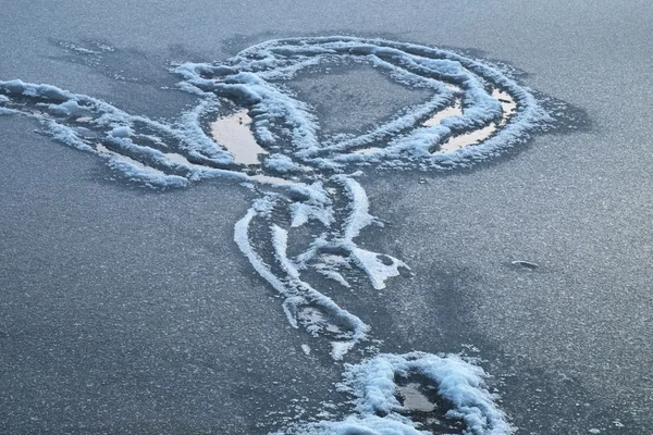 Schneebedeckte Wege in einer Schneedecke auf dem See. gefrorener Wasserspiegel im neblig-kalten Winterabend. — Stockfoto