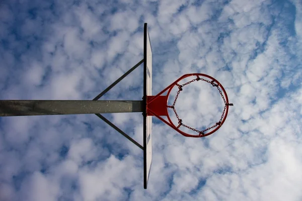 Velha negligência basquete backboard com aro enferrujado acima da quadra de rua. Céu azul nublado no chão. Filtro retrô — Fotografia de Stock