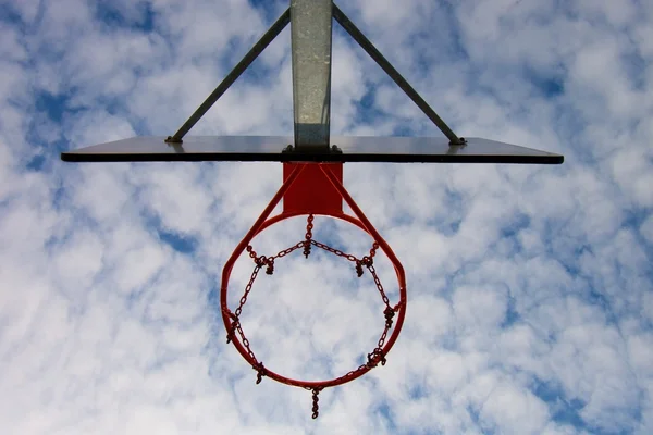 Antiguo tablero de baloncesto descuidado con aro oxidado sobre la cancha de la calle. Cielo nublado azul en bckground. Filtro retro —  Fotos de Stock