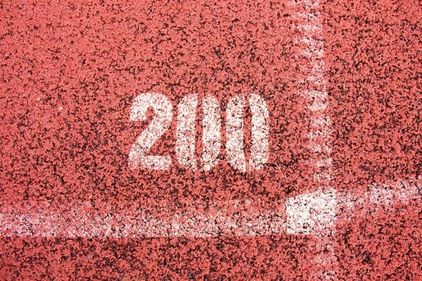 Fehér vonalak és a textúra a futó versenypálya, piros gumi versenypályák kis stadionban — Stock Fotó