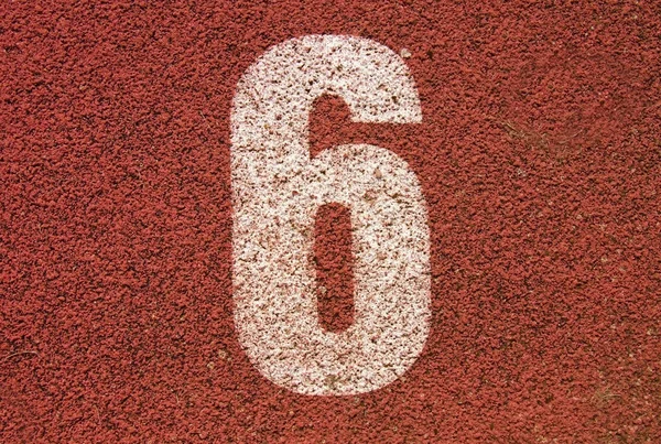 Número de pista branca na pista de corrida de borracha vermelha, textura de pistas de corrida em pequeno estádio ao ar livre — Fotografia de Stock