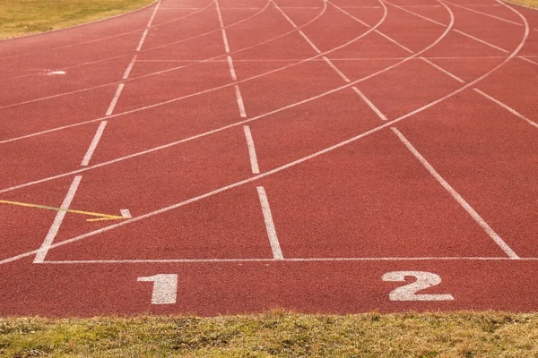 Número de pista blanca en pista de carreras de goma roja, textura de pistas de carreras en pequeño estadio al aire libre — Foto de Stock