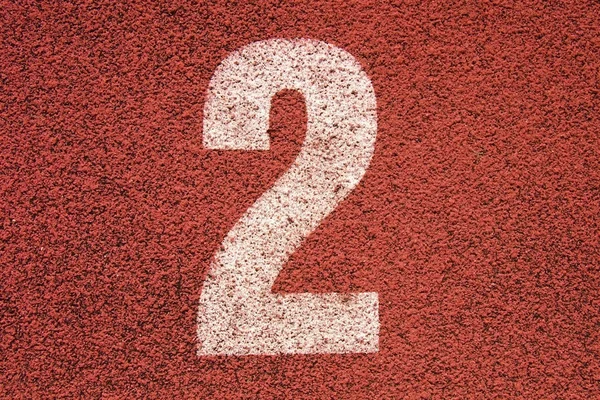 Número de pista branca na pista de corrida de borracha vermelha, textura de pistas de corrida em pequeno estádio ao ar livre — Fotografia de Stock