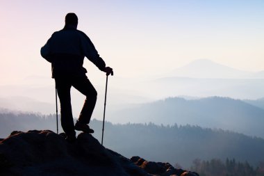 Turist Rehberi el kutup ile doğru yolu göster. Uzun yürüyüşe çıkan kimse sportif sırt çantası ile kayalık Görünüm noktası puslu Vadisi üzerinde durmak. Rocky Dağları'nda güneşli Bahar şafak.