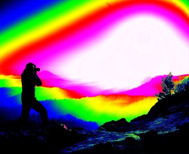 Fantastik Kızılötesi tarama. Turist Polonyalılar ve kayalık görünümü noktasında duran ve puslu sabah peyzaj izlerken büyük sırt çantası ile. Melankolik sonbahar sabahı. Termografi renkleri.