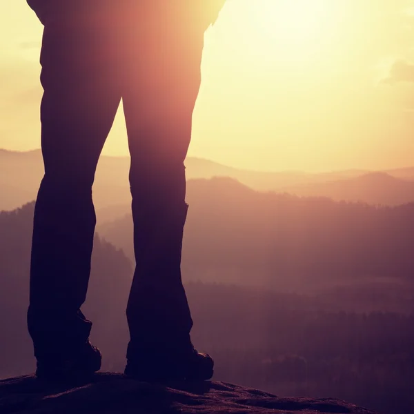 Woman hiker legs in tourist boots stand on mountain rocky peak — Stock Photo, Image