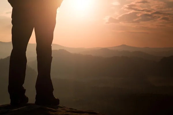女性ハイカー観光ブーツで足が山頂岩の上に立つ — ストック写真