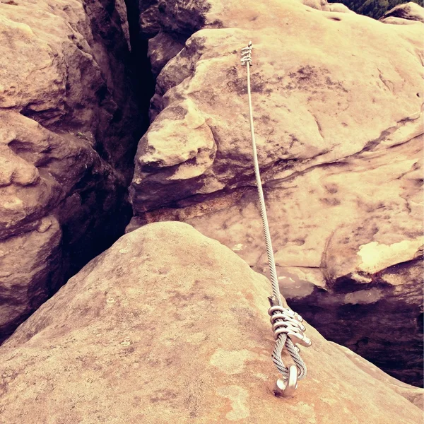 Detail aus Stahlbolzen-Öse und Seilende, die im Sandsteinfelsen verankert sind. Eisen gedrehten Seil im Block durch Schrauben Karabinerhaken fixiert. — Stockfoto