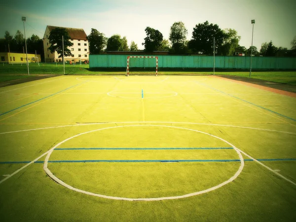 Пустая открытая площадка для гандбола, пластиковая светло-зеленая поверхность на земле и белые синие линии границы . — стоковое фото