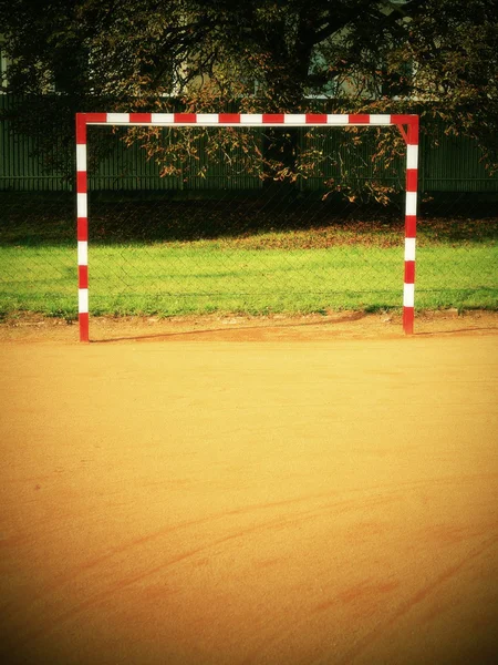 Portão vazio. Futebol ao ar livre ou playground de handebol, superfície de tijolos esmagados vermelho claro no chão — Fotografia de Stock