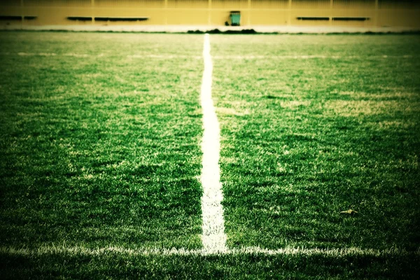 Cruz de linhas brancas pintadas na grama de futebol natural. Textura de relva verde artificial . — Fotografia de Stock