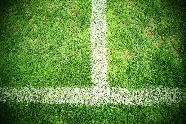 Korsa av målade vita linjer på naturliga fotboll gräs. Grönt konstgräs konsistens. — Stockfoto