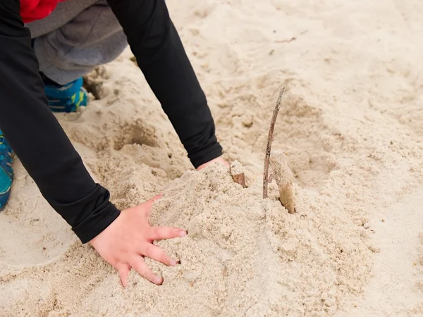 Crianças mão branca na areia salgada na praia . — Fotografia de Stock