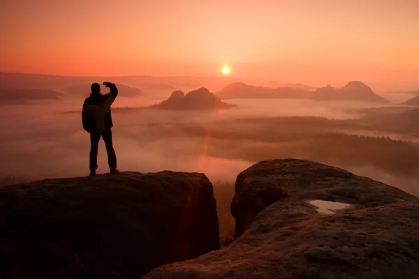 Feliz excursionista está de pie en el pico del parque de imperios rocosos y vigilando el brumoso y brumoso valle de la mañana hasta el Sol. Hermoso momento el milagro de la naturaleza —  Fotos de Stock