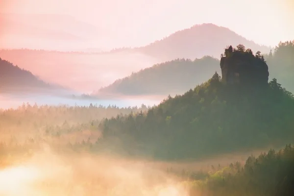 Mistige landschap met mist tussen heuvels en oranje hemel binnen zonsopgang — Stockfoto