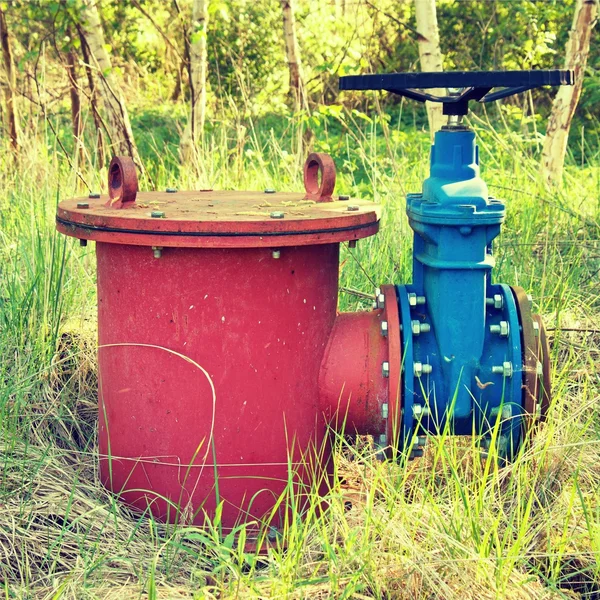 Old expansion pipe of drink water pipes joined with new blue valve and new blue joint members. New dump valve.  Extreme kind of corrosion, metal corroded texture.