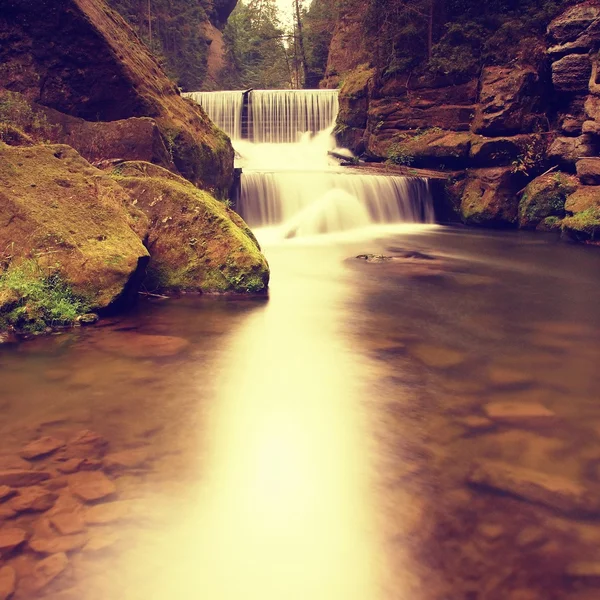 Barrage pierreux sur une petite rivière de montagne. Le ruisseau coule sur des blocs carrés et rend l'eau laiteuse . — Photo