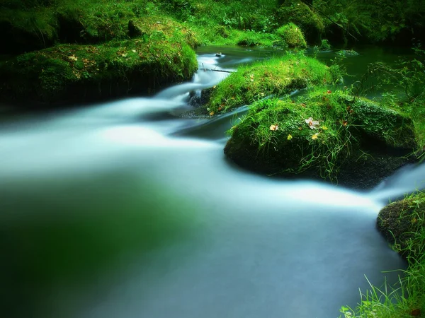 Steinigen Wehr am kleinen Gebirgsfluss. Bach fließt über quadratische Blöcke und macht milchiges Wasser. — Stockfoto