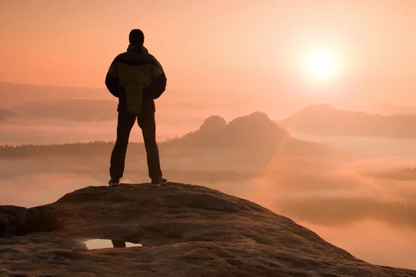 独自徒步旅行者站在一座山的顶上和享受日出 — 图库照片