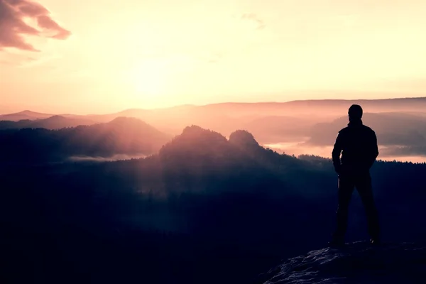 Турист стоит на остром углу скалы из песчаника в парке рок-империй и наблюдает за туманной и туманной утренней долиной до Солнца. Ошибка природы — стоковое фото