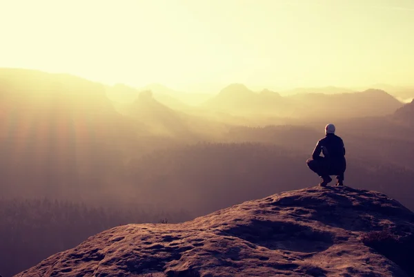 Uzun yürüyüşe çıkan kimse kayalık bir tepe üzerinde oturur ve dağlar sahne tadını çıkarın — Stok fotoğraf
