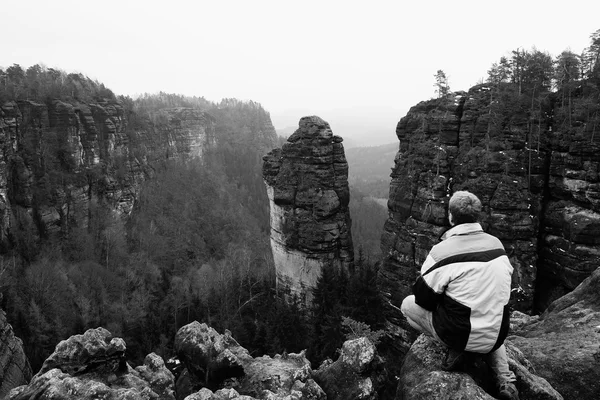 Tourist hiker man on the rock peak  in rocky mountains — Stock Photo, Image