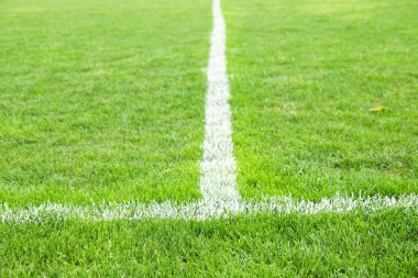Boyalı beyaz satırlık doğal futbol çim üzerinde çapraz. Suni çim yeşil doku. 