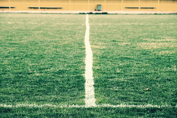 Kreuz gemalter weißer Linien auf natürlichem Fußballrasen. Beschaffenheit des Kunstrasens. — Stockfoto