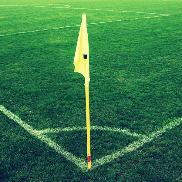 Bandera amarilla en esquina del patio de fútbol natural, viento perezoso soplando — Foto de Stock